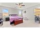 Inviting bedroom features a ceiling fan, two windows and a comfortable bed with purple bedding at 2672 Painted Mist Ct, Las Vegas, NV 89142