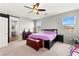 Bright bedroom featuring desert views, ceiling fan, and a comfortable bed with purple bedding at 2672 Painted Mist Ct, Las Vegas, NV 89142