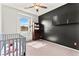 Bedroom featuring a gray crib, stylish black accent wall, carpet floors, and cabinet for storage at 2672 Painted Mist Ct, Las Vegas, NV 89142