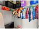Walk-in closet filled with colorful clothing on hangers, black plastic storage bins, and an ironing board at 2672 Painted Mist Ct, Las Vegas, NV 89142