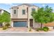 Charming two-story home with desert landscaping and a blue garage door at 2672 Painted Mist Ct, Las Vegas, NV 89142