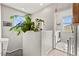 Bright hallway with plants next to a window and a laundry room visible through an open door at 2672 Painted Mist Ct, Las Vegas, NV 89142