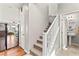 Bright hallway with staircase, white banister, and modern fixtures at 2672 Painted Mist Ct, Las Vegas, NV 89142