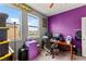 Bright home office with purple accent wall, a desk, two windows, and lots of natural light at 2672 Painted Mist Ct, Las Vegas, NV 89142