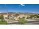 View of the community with mountain views, desert landscaping, and tile roofs at 2728 Holmfault St, Henderson, NV 89044