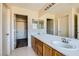 Bathroom with dual sinks, wood cabinets, and a large mirror at 2728 Holmfault St, Henderson, NV 89044