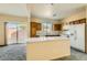 Functional kitchen with an island, white appliances, sliding door, and adequate counter space at 2728 Holmfault St, Henderson, NV 89044