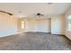 Spacious living room features carpet flooring, modern ceiling fan, and lots of natural light at 2728 Holmfault St, Henderson, NV 89044