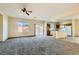 Spacious living area features carpet, a ceiling fan, and easy access to the kitchen at 2728 Holmfault St, Henderson, NV 89044
