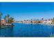 Scenic lake view featuring waterfront homes, palm trees, and mountain views in the distance on a bright, sunny day at 3151 Soaring Gulls Dr # 1023, Las Vegas, NV 89128
