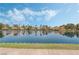 Picturesque lake view with manicured green lawn bordering the water, and clear reflection of the sky and homes at 3151 Soaring Gulls Dr # 1023, Las Vegas, NV 89128