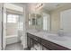 Bathroom featuring double sink vanity, mirror, and tiled shower with curtain at 3165 Via Como, Henderson, NV 89044