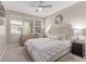 Neutral bedroom with a large upholstered headboard bed, dresser, and decorative mirror at 3165 Via Como, Henderson, NV 89044