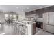 Modern kitchen with a long breakfast bar, stainless steel appliances, and stylish dark cabinets at 3165 Via Como, Henderson, NV 89044