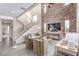 Modern living room with a soaring brick accent wall and staircase with stainless steel banisters at 3165 Via Como, Henderson, NV 89044
