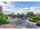 This is a crosswalk view of the town square with mature landscaping and park benches at 3165 Via Como, Henderson, NV 89044