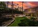 Lush backyard with a cozy patio, well-maintained lawn, a rock feature, and mature trees at 3341 Heavenly View Ct, Las Vegas, NV 89117