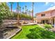 Expansive backyard featuring lush green grass, privacy landscaping, and a rock waterfall pool at 3341 Heavenly View Ct, Las Vegas, NV 89117