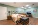 View of a green guest bedroom with a full size bed, leather sofa, and television at 3341 Heavenly View Ct, Las Vegas, NV 89117