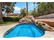 Inviting pool featuring a unique rock waterfall and lush landscaping, providing a serene backyard retreat at 3341 Heavenly View Ct, Las Vegas, NV 89117