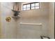 Tiled shower with a corner shelves for toiletries, gold shower head and a grab bar for accessibility at 3341 Heavenly View Ct, Las Vegas, NV 89117