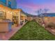 Inviting backyard with artificial grass, string lights, and covered patio; perfect for outdoor living and entertaining at 352 Dandelion Brook Ct, Las Vegas, NV 89148