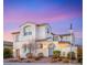 Elegant two-story home boasting a white exterior, arched entry, and tile roof against a colorful evening sky at 352 Dandelion Brook Ct, Las Vegas, NV 89148