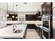 Modern kitchen featuring dark cabinets, a large island, stainless steel appliances and wood-look tile flooring at 352 Dandelion Brook Ct, Las Vegas, NV 89148