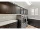 A well-equipped laundry room with washer, dryer, ample storage, and counter space at 352 Dandelion Brook Ct, Las Vegas, NV 89148
