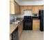 Kitchen with wooden cabinets and black appliances at 3930 University Center Dr # 702, Las Vegas, NV 89119