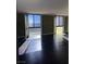 Bright living room featuring dark hardwood floors and large windows with city views at 3930 University Center Dr # 702, Las Vegas, NV 89119