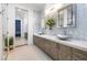 Contemporary bathroom features dual sinks, modern lighting, and textured accent wall, creating a spa-like ambiance at 4140 Coneflower St, Las Vegas, NV 89135