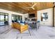 Relax on the covered patio with ceiling fans, TV, and comfortable seating with backyard views at 4140 Coneflower St, Las Vegas, NV 89135