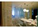 Elegant marble bathroom featuring dual sinks, a walk-in shower, and modern lighting fixtures at 4381 W Flamingo Rd # 3118, Las Vegas, NV 89103