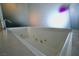 Modern bathtub featuring a unique design with a frosted glass panel, with sleek faucet, and marble surround at 4381 W Flamingo Rd # 3118, Las Vegas, NV 89103