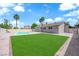 Expansive backyard featuring a sparkling pool, green grass, and desert landscaping at 4508 Rip Van Winkle Ln, Las Vegas, NV 89102