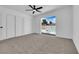 Bedroom with neutral carpeting, a ceiling fan, a closet with sliding doors and an outdoor view of the pool at 4508 Rip Van Winkle Ln, Las Vegas, NV 89102