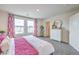 Bedroom with plush bedding, dresser, and two windows with patterned curtains at 48344 Orchid Ridge Ave # 104, Las Vegas, NV 89141