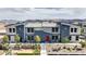 Attractive modern home exterior with colorful red door, desert landscaping, and mountain views in the distance at 48344 Orchid Ridge Ave # 104, Las Vegas, NV 89141