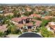 Expansive aerial view of a luxury home with a terracotta roof, lush landscaping, and surrounding neighborhood at 5079 Mountain Top Cir, Las Vegas, NV 89148