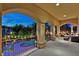 Covered balcony with arched columns overlooks a meticulously landscaped backyard, complete with pool and gazebo, perfect for relaxation at 5079 Mountain Top Cir, Las Vegas, NV 89148