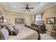 Elegant bedroom featuring tray ceilings, ceiling fan, and wooden furniture at 5079 Mountain Top Cir, Las Vegas, NV 89148