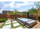Landscaped backyard with modern pavers, a luxurious hot tub, and ambient string lights creating a serene retreat at 5981 Smith Valley Rd, Las Vegas, NV 89148