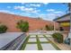 Landscaped backyard with an in-ground hot tub, fire pit, and privacy wall at 5981 Smith Valley Rd, Las Vegas, NV 89148
