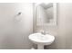 A pedestal sink with mirror and fixtures are in this half bathroom at 5981 Smith Valley Rd, Las Vegas, NV 89148