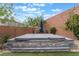 Relaxing backyard featuring an in-ground hot tub, surrounding trees, and privacy wall at 5981 Smith Valley Rd, Las Vegas, NV 89148
