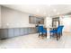 Open kitchen featuring gray cabinets, granite countertops, an island with seating and stainless steel appliances at 5981 Smith Valley Rd, Las Vegas, NV 89148