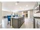 Bright open kitchen featuring a center island with seating, stainless appliances, and tile floors at 5981 Smith Valley Rd, Las Vegas, NV 89148