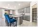 Open kitchen view with stainless steel appliances, gray cabinetry, granite counters, and bar stool seating at 5981 Smith Valley Rd, Las Vegas, NV 89148