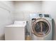 Bright laundry room featuring a modern, front-load washer and dryer with overhead storage at 6622 Black Oil Dr, Las Vegas, NV 89122